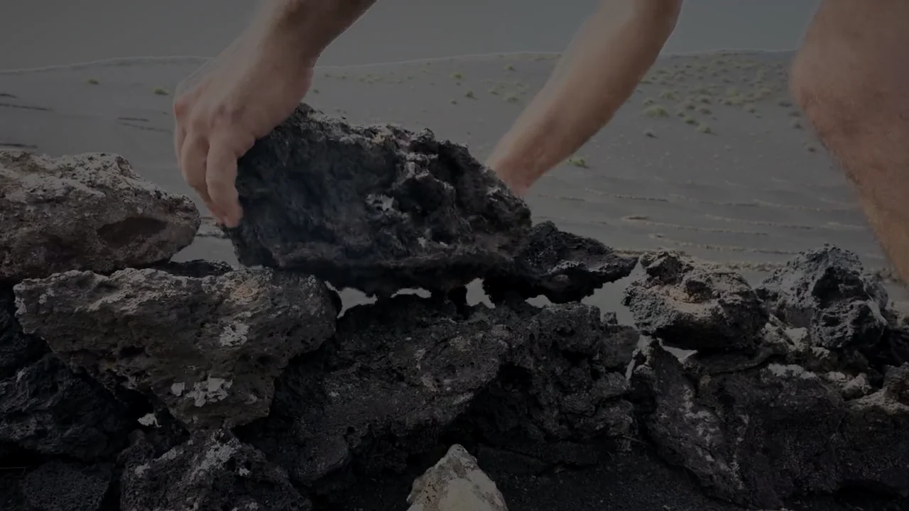 Hands setting a lava stone into the wall